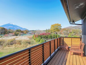 Eine Holzterrasse mit Blick auf einen Berg und Herbstlaub.