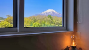 Una ventana con vistas a una montaña y árboles.