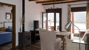 Una camera accogliente con un letto, una scrivania, una sedia, una TV e un camino.