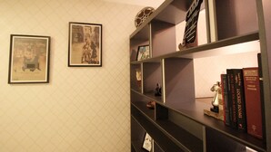A bookshelf with framed pictures and books. - MaxStays Max Home at The Venice Residences (Taguig)