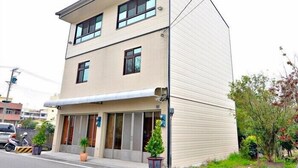 A two-story building with a flat roof, large windows, and a covered entrance area. - Lvyou B&B (Tianwei)