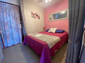 Ein Schlafzimmer mit Bett, Spiegel und Tür.