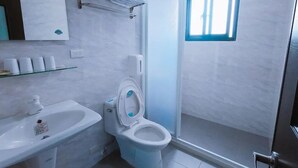 Un baño moderno con inodoro, lavamanos y ducha.