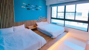 Habitación de hotel moderna con dos camas, un ventanal grande y una pared azul decorada con motivos de peces.