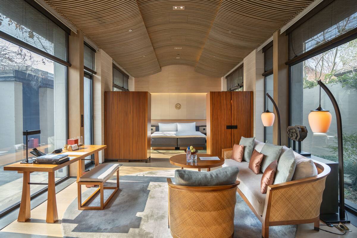 Une chambre d’hôtel moderne équipée d’un grand lit, d’un canapé, d’un bureau et d’une table à manger.