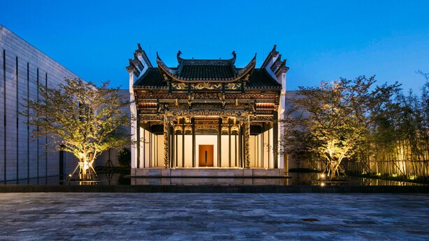 A traditional Chinese building with ornate architecture, a central wooden door, and a courtyard with trees. - Ahn Luh Zhujiajiao (Shanghai)