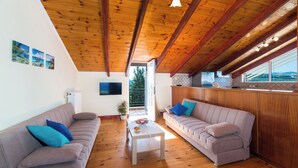 A modern living room with two sofas, a coffee table, and a TV mounted on the wall.