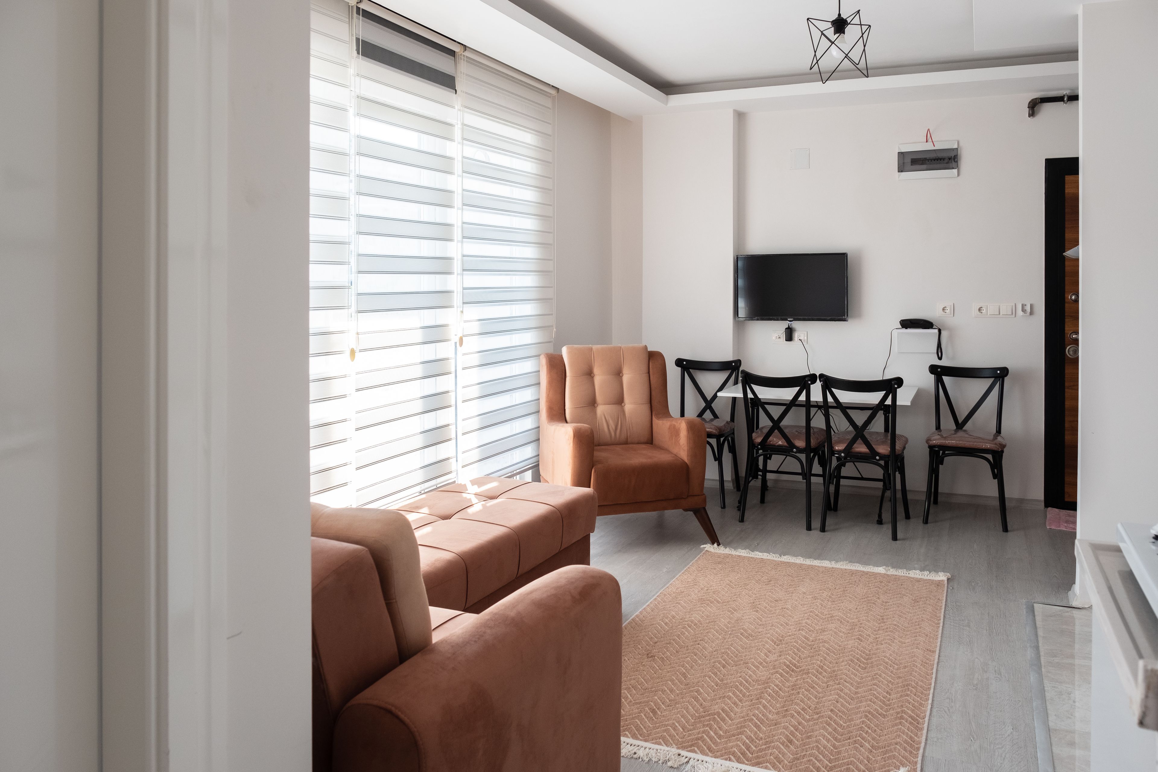 A modern living room with a sofa, a coffee table, and a TV mounted on the wall.