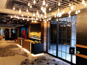 Een moderne lobby met een receptiebalie, een brievenbus en een groot raam.