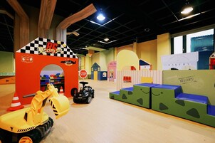 A children's play area with a racing theme, including a speed car and a fire truck.