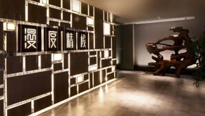 A modern interior with a geometric wall design and a sculpture. - M Do Hotel (Weifang)