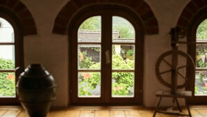 A room with a large window, a wooden floor, and a spinning wheel. - Country House Stara Kapela (Nova Kapela)