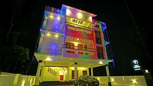 Un edificio de varios pisos con balcones, un automóvil estacionado al frente y una bicicleta.