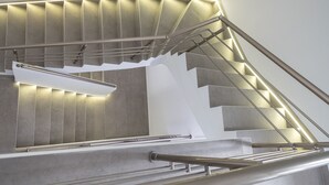 Un escalier moderne avec des rampes en métal et des marches éclairées.