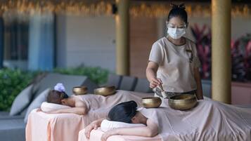 Experience a serene spa setting with a central massage table surrounded by decorative bowls, promoting holistic wellness and relaxation.