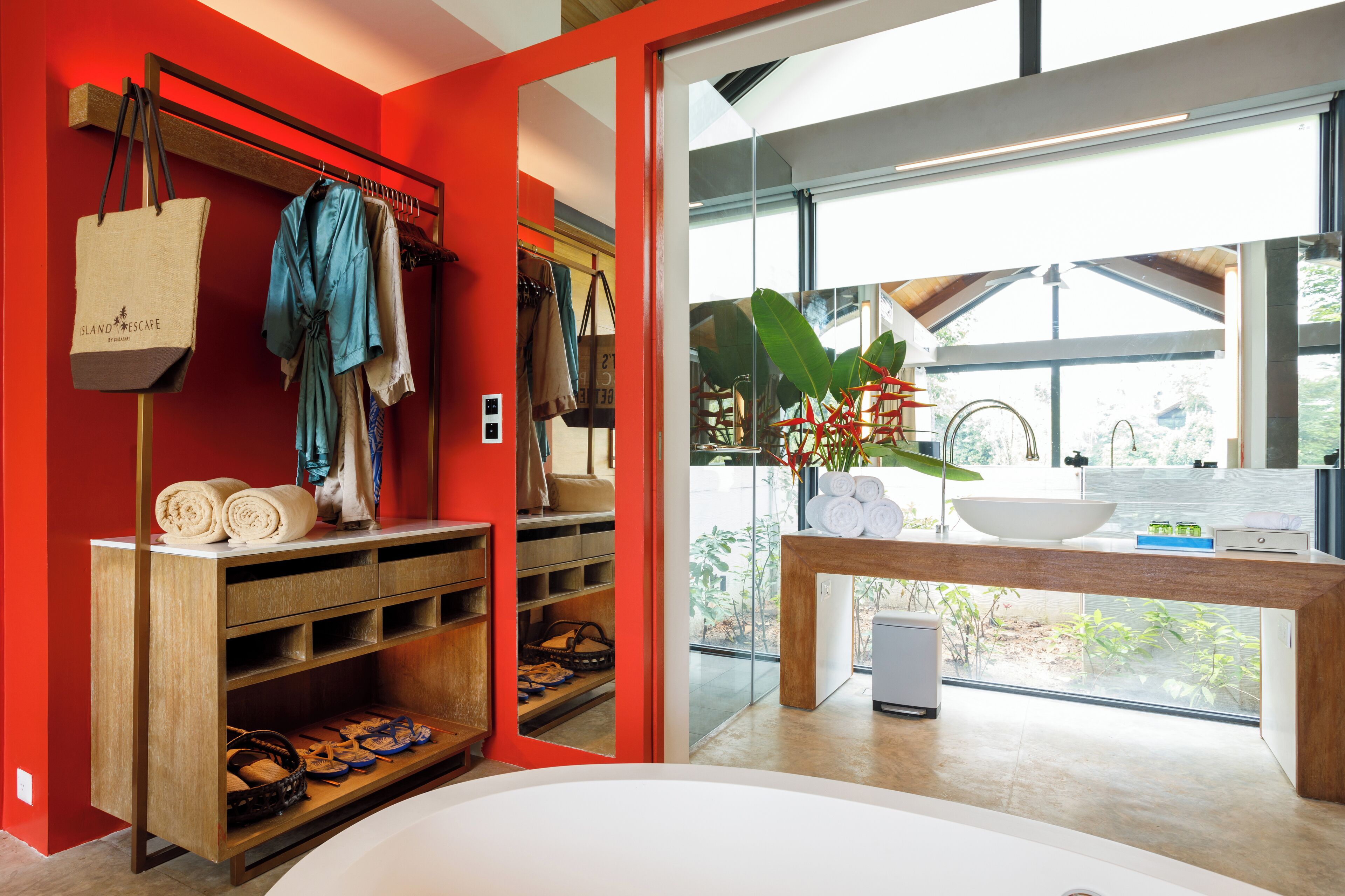 A modern bathroom with a large window, a wooden vanity, and a built-in shoe rack.