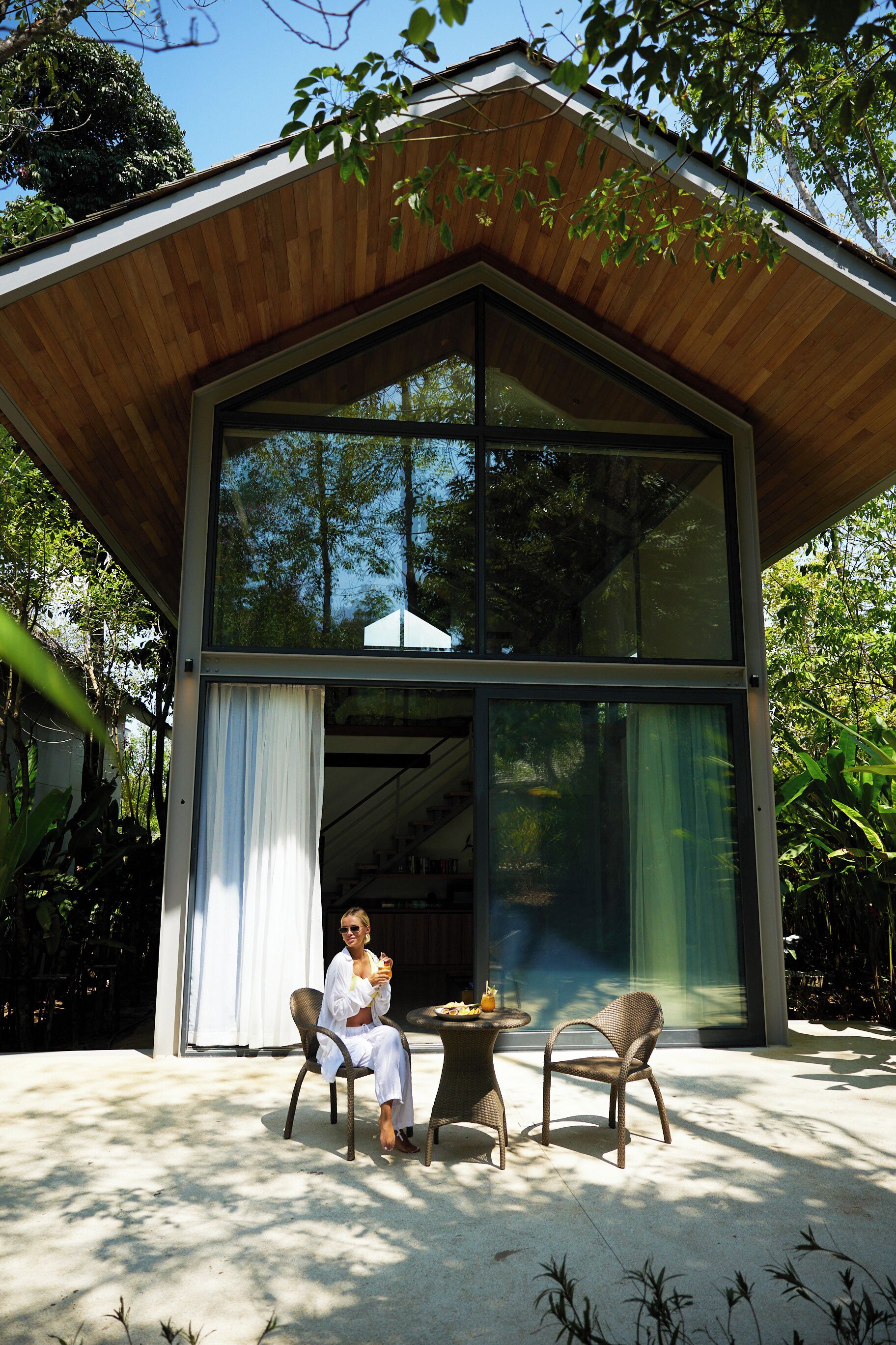 Una casa moderna con ventanas amplias y techo de madera.