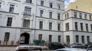 A multi-story building with a classic architectural style, featuring symmetrical windows and a central entrance. - ApartamentSun White (Wroclaw)