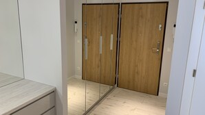 A room with a wooden wardrobe, a mirror, and a wooden floor. - ApartamentSun White (Wroclaw)