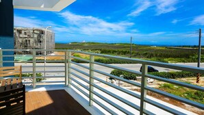Een balkon met uitzicht op een bouwplaats en de zee.