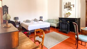 Una habitación con cama, escritorio, silla, chimenea y un globo terráqueo en un estante.