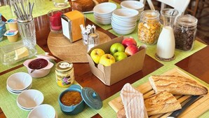 Un bufé de desayuno con diferentes alimentos y utensilios sobre una mesa de madera.
