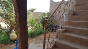A staircase with a metal railing leading to a higher level. - Riad Desert Camel (Taouz)
