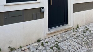 A building with a black door and two windows, each with a number plate indicating '20'. - Porta 20 - Vacation Home (Loulé)