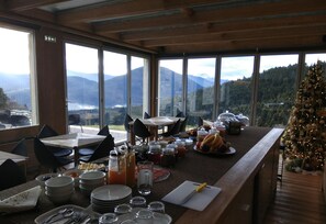 A breakfast bar with a mountain view, wooden interior, and a Christmas tree. - Escapade Luxury Residences (Karpenisi)