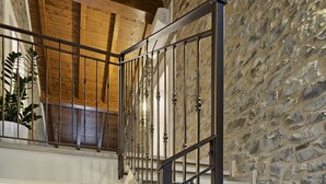 Ein geräumiger Lofts mit Holztreppe und einer Steinwand.