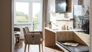 A modern kitchen with a wooden countertop, a built-in TV, and a view of the outdoors. - Hotel Derichsweiler Hof (Nümbrecht)