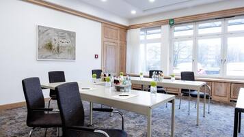 A conference room with a long table, chairs, and a window with a view.
