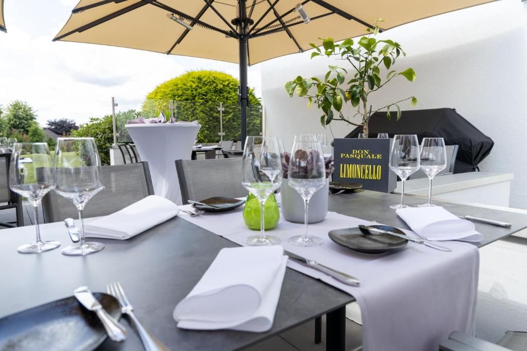 A dining table set for two with wine glasses, a menu, and a sign reading 'Pianissimo Limoncello'.