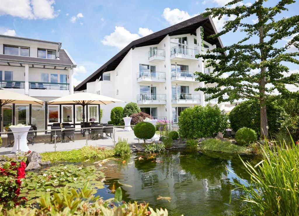A hotel with a pond, outdoor seating, and a well-maintained garden.