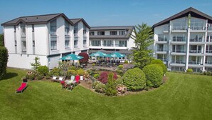 A hotel with a courtyard featuring outdoor seating and a pool area. - Hotel Derichsweiler Hof (Nümbrecht)