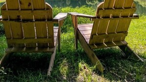 Two Adirondack chairs facing a lake with a forested hill in the background under a clear blue sky. - Shepherds Retreat - 2 miles to I-65 (Montevallo)