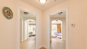 A hallway with two doorways leading to bedrooms, a ceiling light, and a decorative plate on the wall. - Reunion Resort Townhome - minutes from Disney! (Reunion)