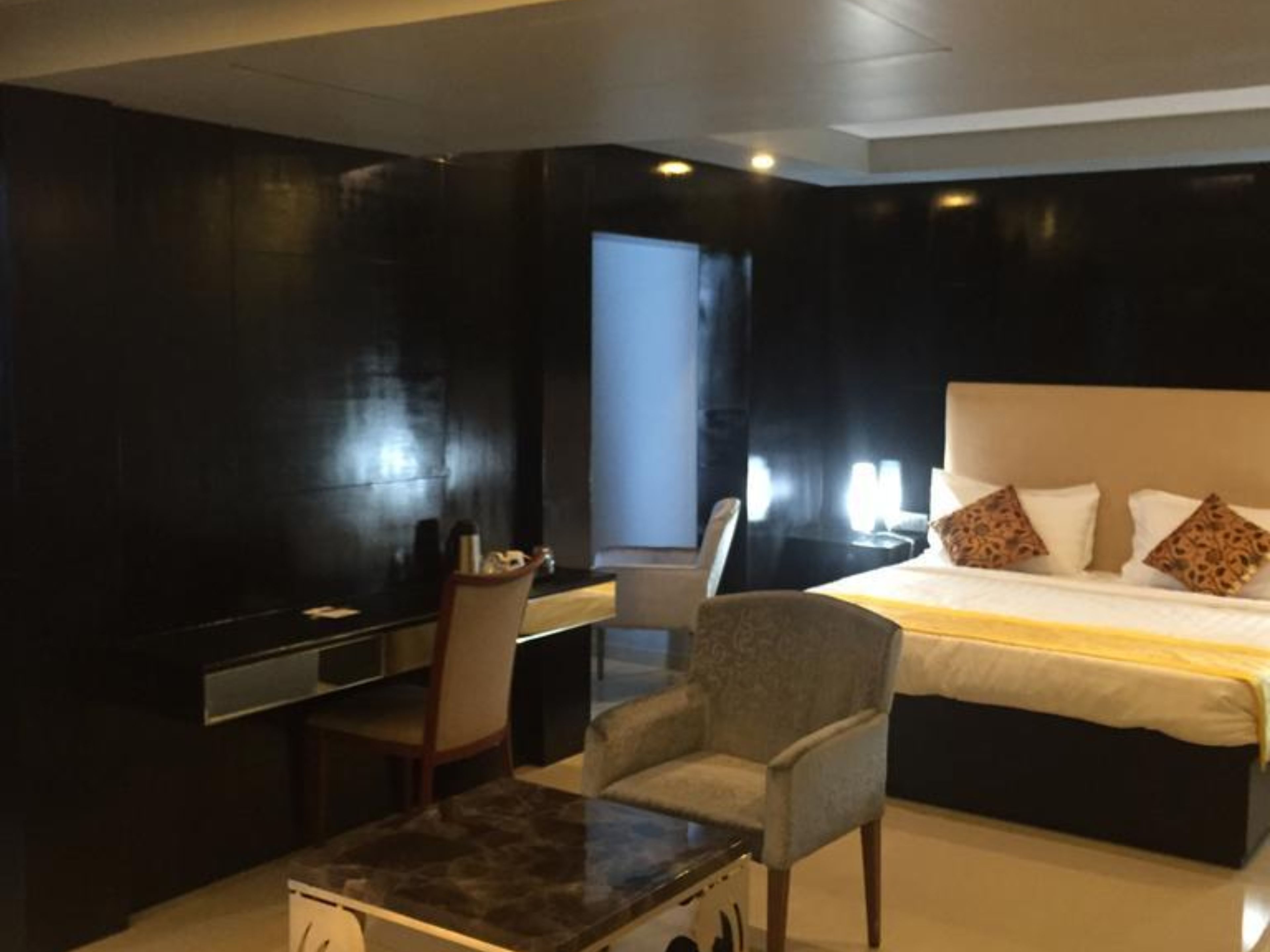 Une chambre d’hôtel moderne, dotée d’un grand lit, d’un bureau et d’une chaise.
