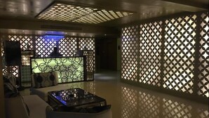 A modern interior with a sofa, a coffee table, and decorative panels with geometric patterns. - Le Raj Courtyard (Gummidipundi)