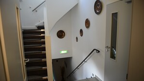 A staircase with a handrail, a door with a window, and wall-mounted plates. - Pension und Monteurzimmer VICTORIA (Ludwigshafen)