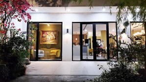 Una entrada de hotel moderna con puertas de cristal, un cuadro enmarcado y asientos interiores visibles a través de las puertas.