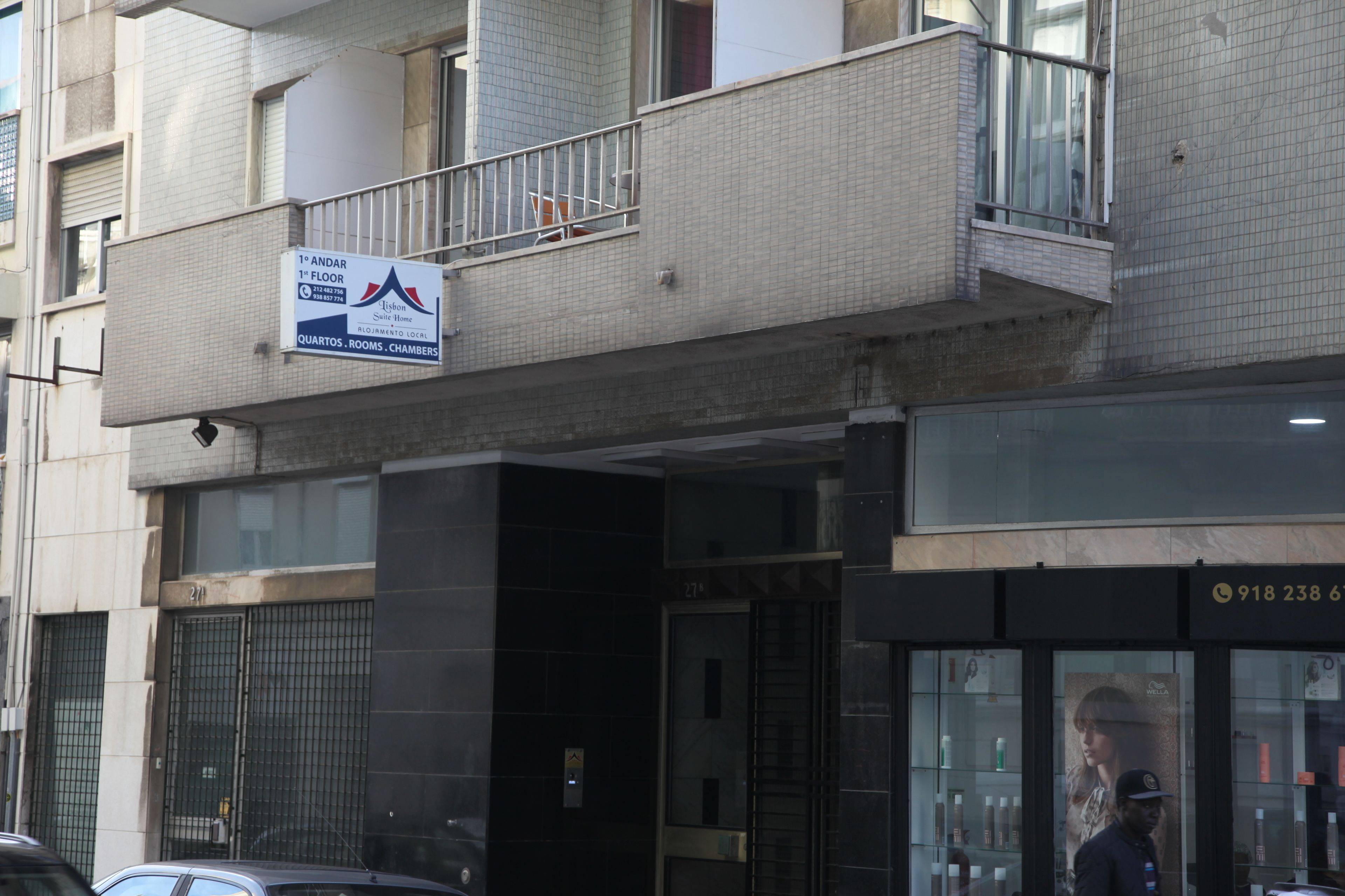 Un edificio con un letrero que anuncia apartamentos en el primer piso y una tienda con un número de teléfono.
