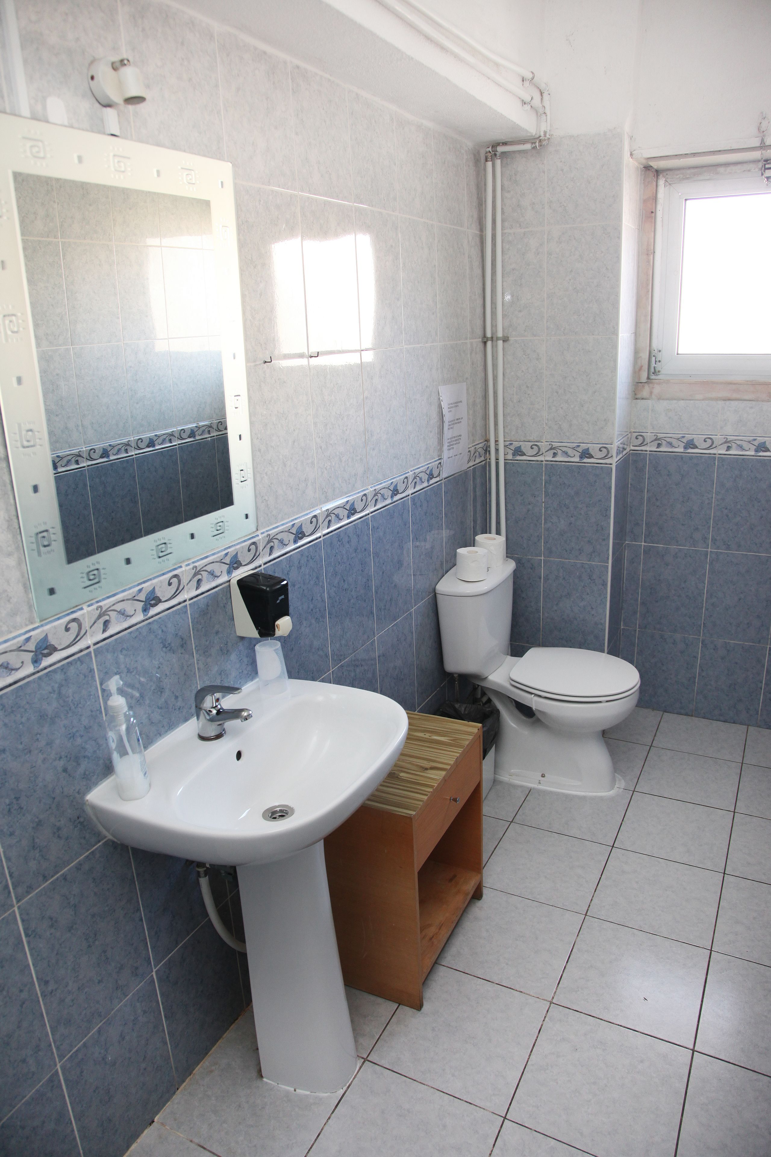 A bathroom with a white sink, toilet, and shower.