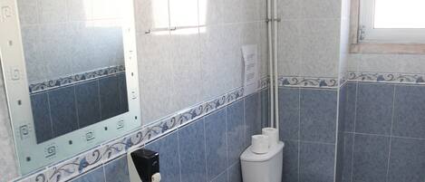 A bathroom with a white sink, toilet, and shower.