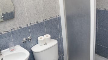 Une salle de bain comprenant un lavabo, des toilettes et un espace douche.