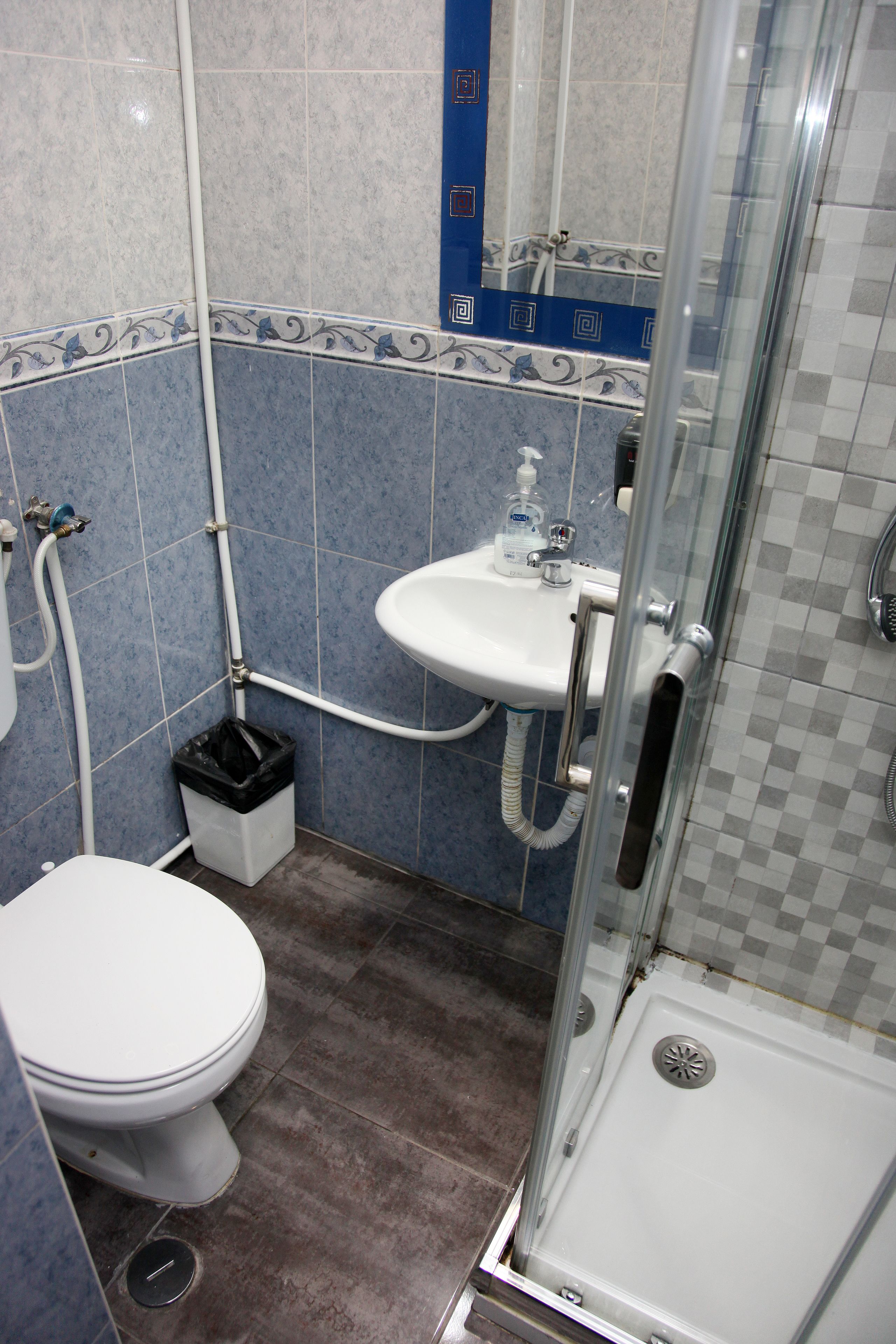A bathroom with a toilet, sink, and shower.