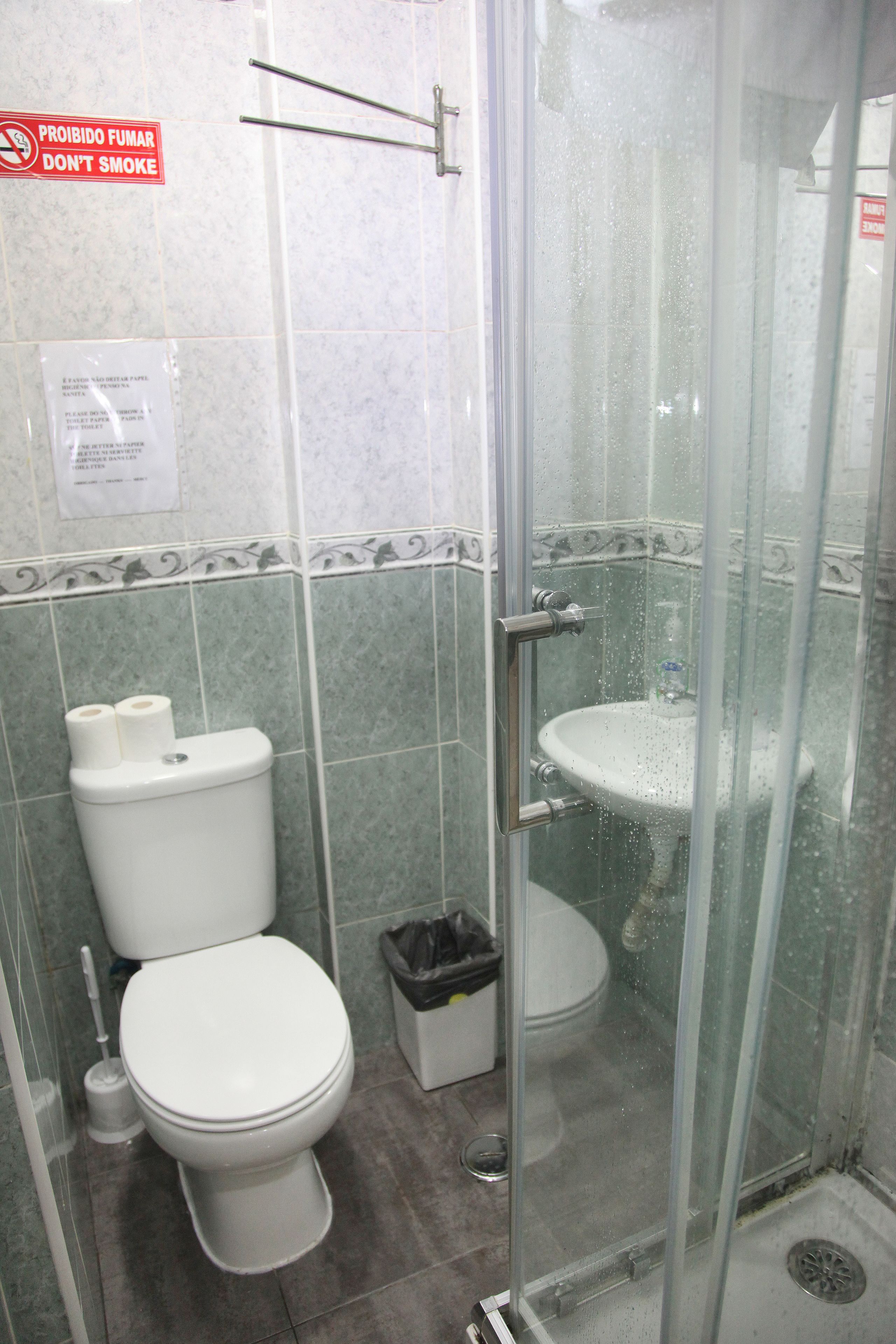Een badkamer met toilet, wastafel en douchecabine.