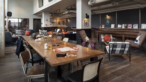 Una sala de reuniones amplia y moderna con una larga mesa de madera, asientos cómodos y un gran ventanal con vistas a la ciudad.