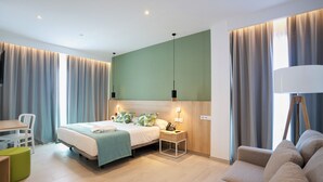 Une chambre d’hôtel moderne avec un lit, une table de chevet, une lampe et un mur d’accent vert.