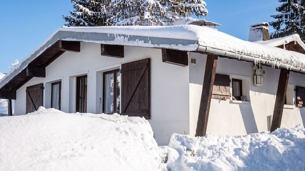 A snow-covered building with a sloped roof, wooden beams, and multiple windows. - Homerez - Chalet in Métabief (Métabief)